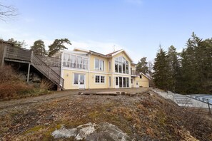 Ett tvåvåningshus med en trätrappa som leder upp till en veranda.