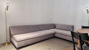 A corner living area with a light gray sectional sofa, a round wooden table, and two black chairs. - ⦗Malgrate/Lecco⦘ The Court of the Lake (Malgrate)