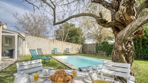 A poolside breakfast setup with a table, chairs, and a tree. - Awesome home in Rochefort (Rochefort)