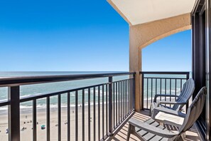 Een balkon met uitzicht op het strand en de oceaan.