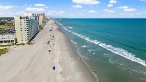 An aerial view of a beach with buildings along the shore, a clear sky, and the ocean. - Oceanfront Resort 2Br Condo Pools and Hot Tubs (Myrtle Beach)