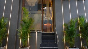 The exterior of Embassy Park with a modern entrance, air conditioning units, and potted plants. - EMBASSY PARK Near US consulate (Chennai)