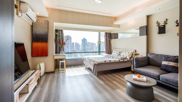 A modern hotel room with a bed, sofa, and a small table. - Tech-X apartment hotel (Shanghai)