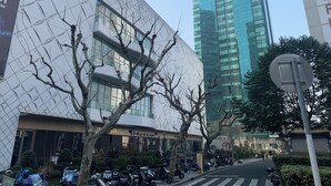 A modern building with a geometric facade, a visible restaurant named "LUMBAR," and a street with parked scooters. - Tech-X apartment hotel (Shanghai)