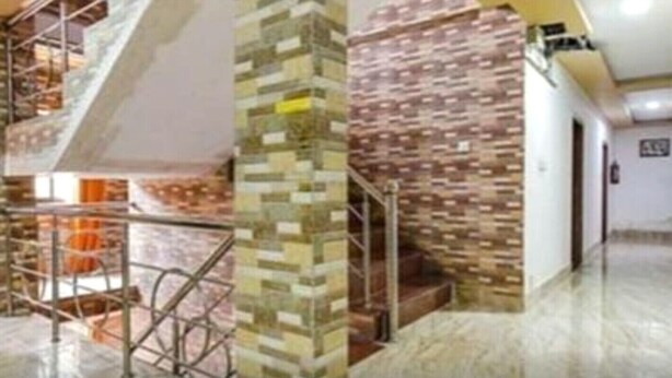 A modern interior with a staircase, a pillar with a mosaic pattern, and a hallway with a patterned wall. - Hotel Tak (Udaipur)
