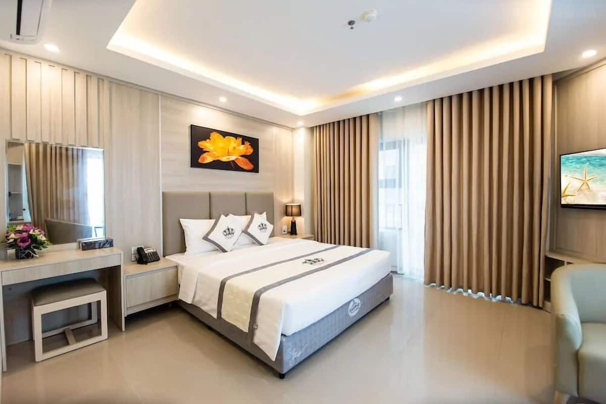 Une chambre d’hôtel moderne avec un grand lit, des tables de chevet, un bureau, une chaise et un téléviseur.