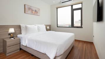 A modern hotel room with a large bed, a bedside table with a lamp, an air conditioning unit, a large window, and a painting on the wall.