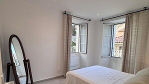 Ein Schlafzimmer mit Bett, Schminktisch, Spiegel und Nachttischlampe.