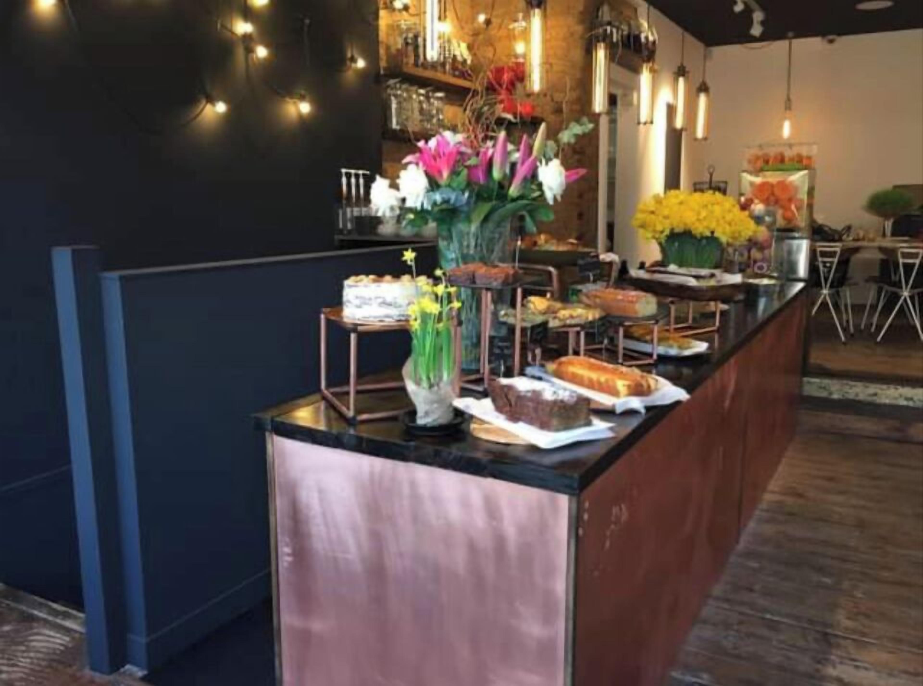 A buffet setup with various food items and a vase of flowers.
