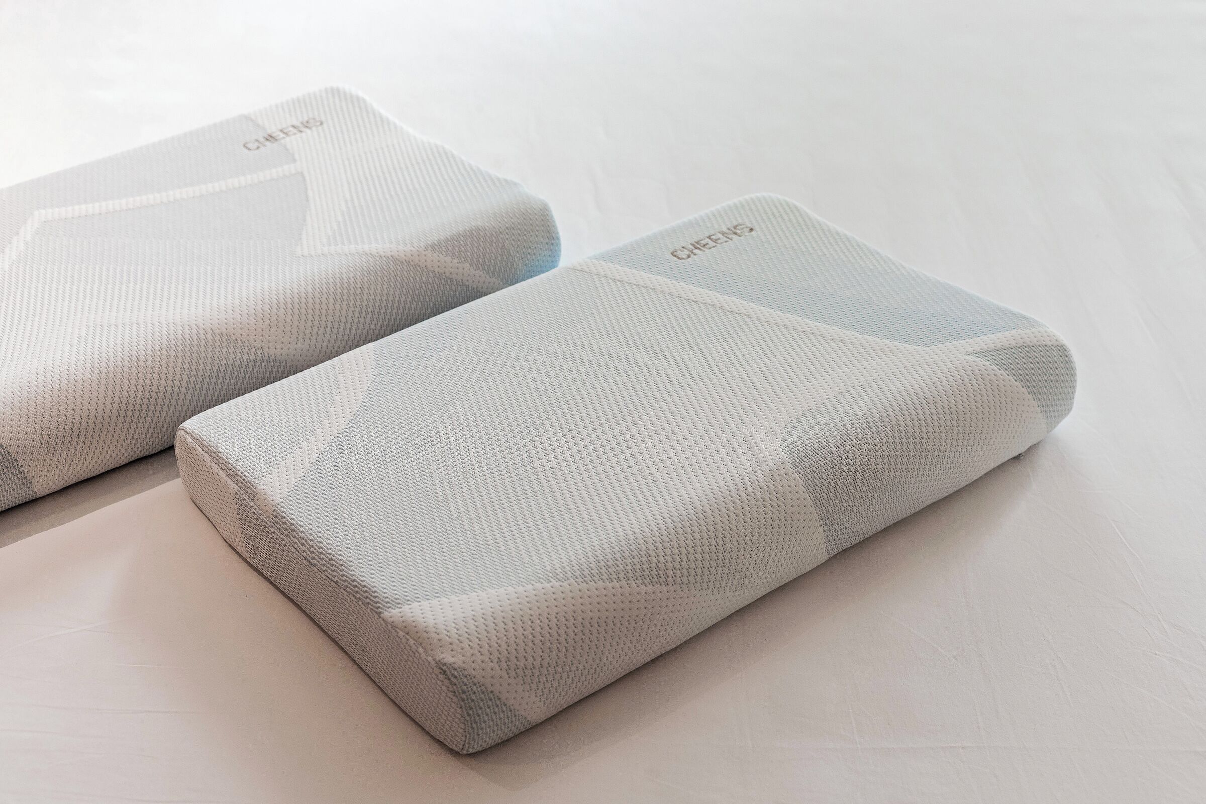 Two rolled-up mattresses with a textured surface and the word "CHEENS" visible on them.