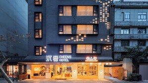 A hotel with a modern facade, multiple windows, and a well-lit entrance. - Cheens Hotel (Chengdu)