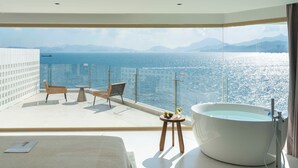 A modern room with a large bathtub, a balcony with a view of the sea, and a bed. - Shenzhen Secret Wild Reef Beautiful Stay (Shenzhen)