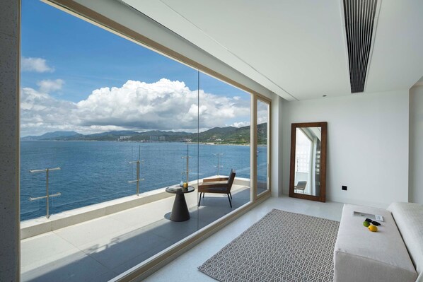 A modern room with a large window overlooking a body of water and mountains. - Shenzhen Secret Wild Reef Beautiful Stay (Shenzhen)