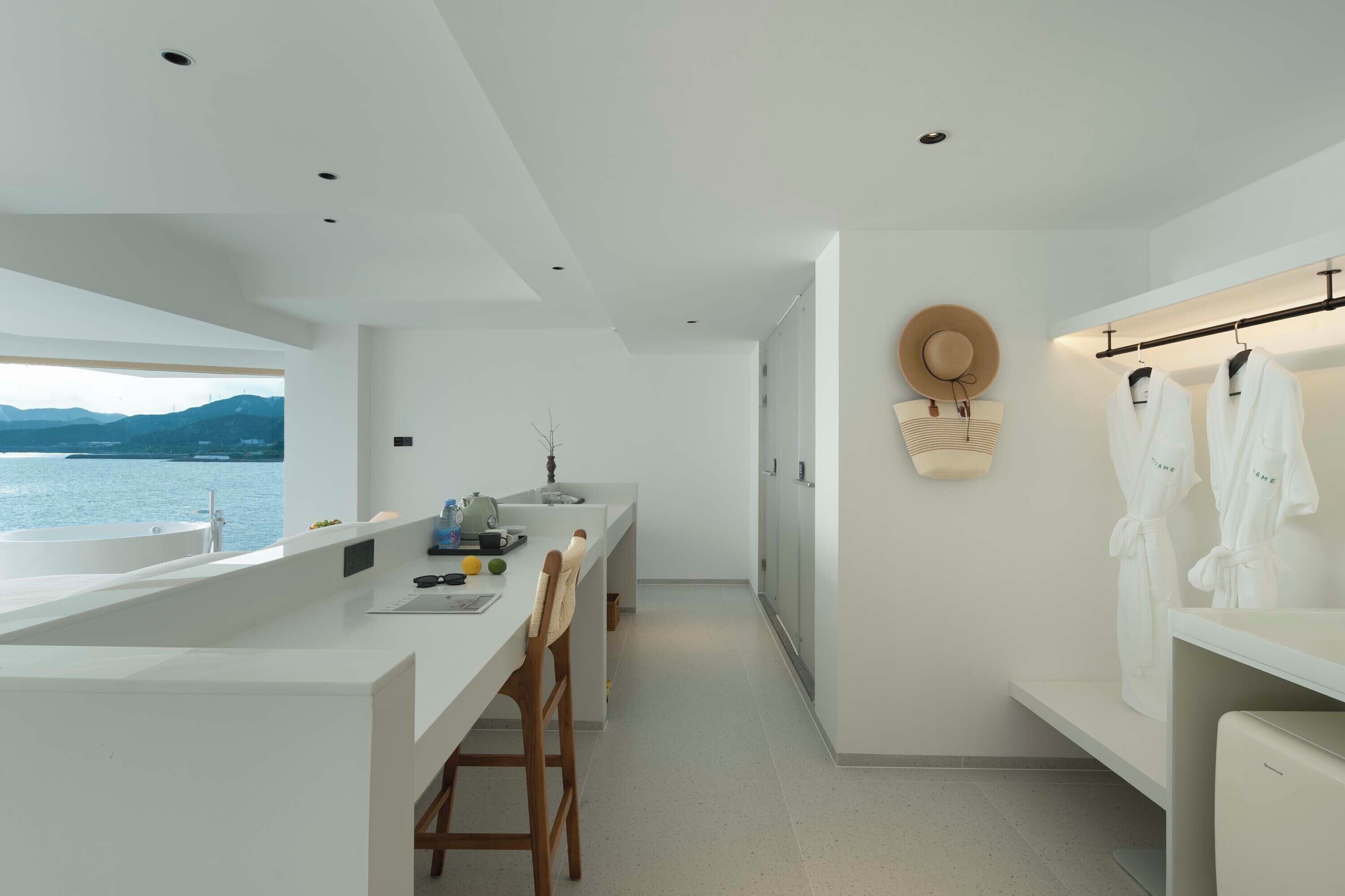 Una cocina moderna con una isla grande, un comedor y vista al mar.