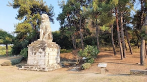 Standing proudly in a forested area, this historic monument features a majestic lion statue.