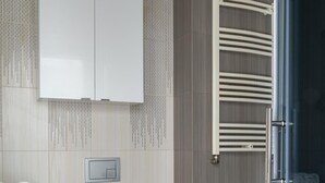 A modern bathroom with a toilet, sink, and shower area. - Przytulny apartament KOLEJOVA 13 (Nowy Targ)