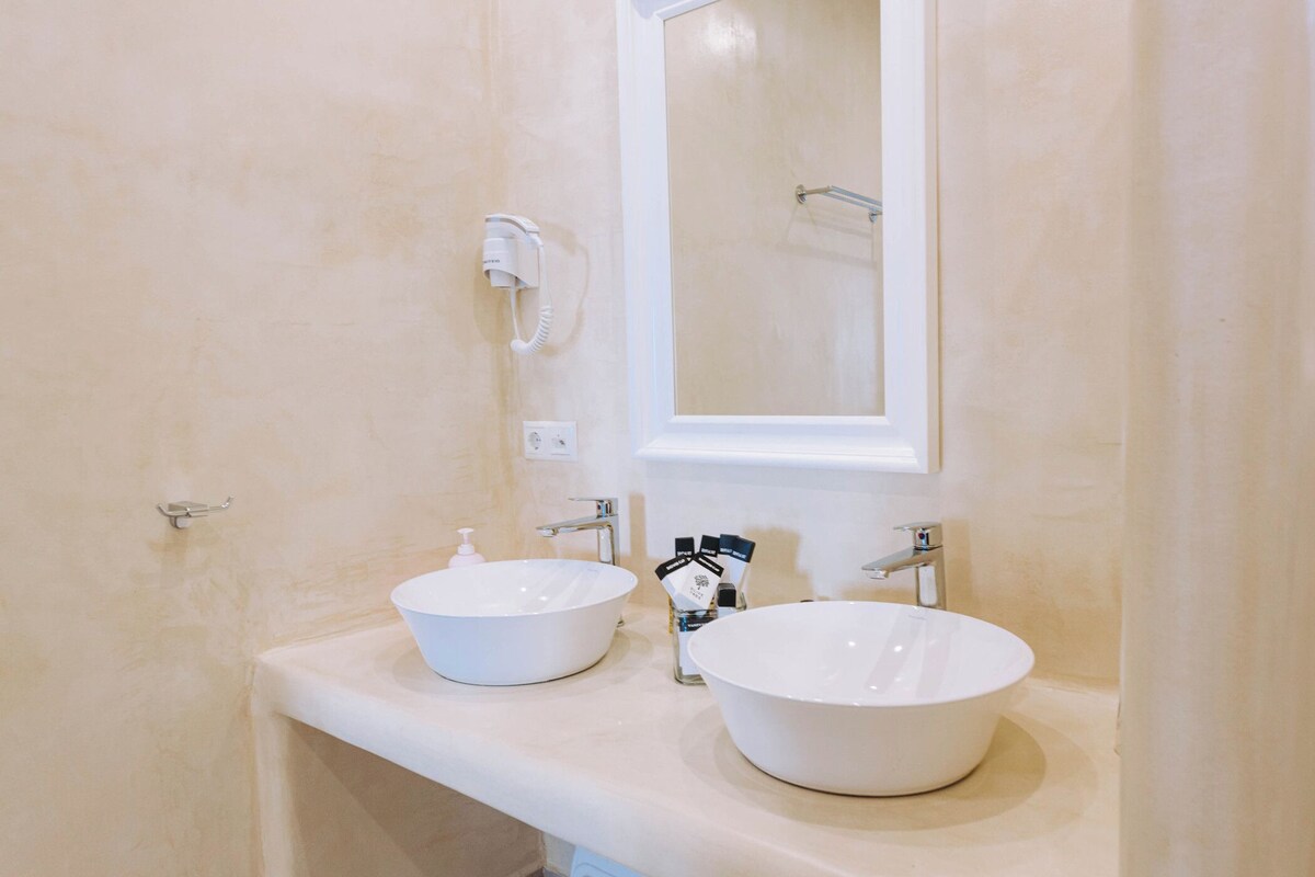 A bathroom with two white sinks, a mirror, and a towel rack.