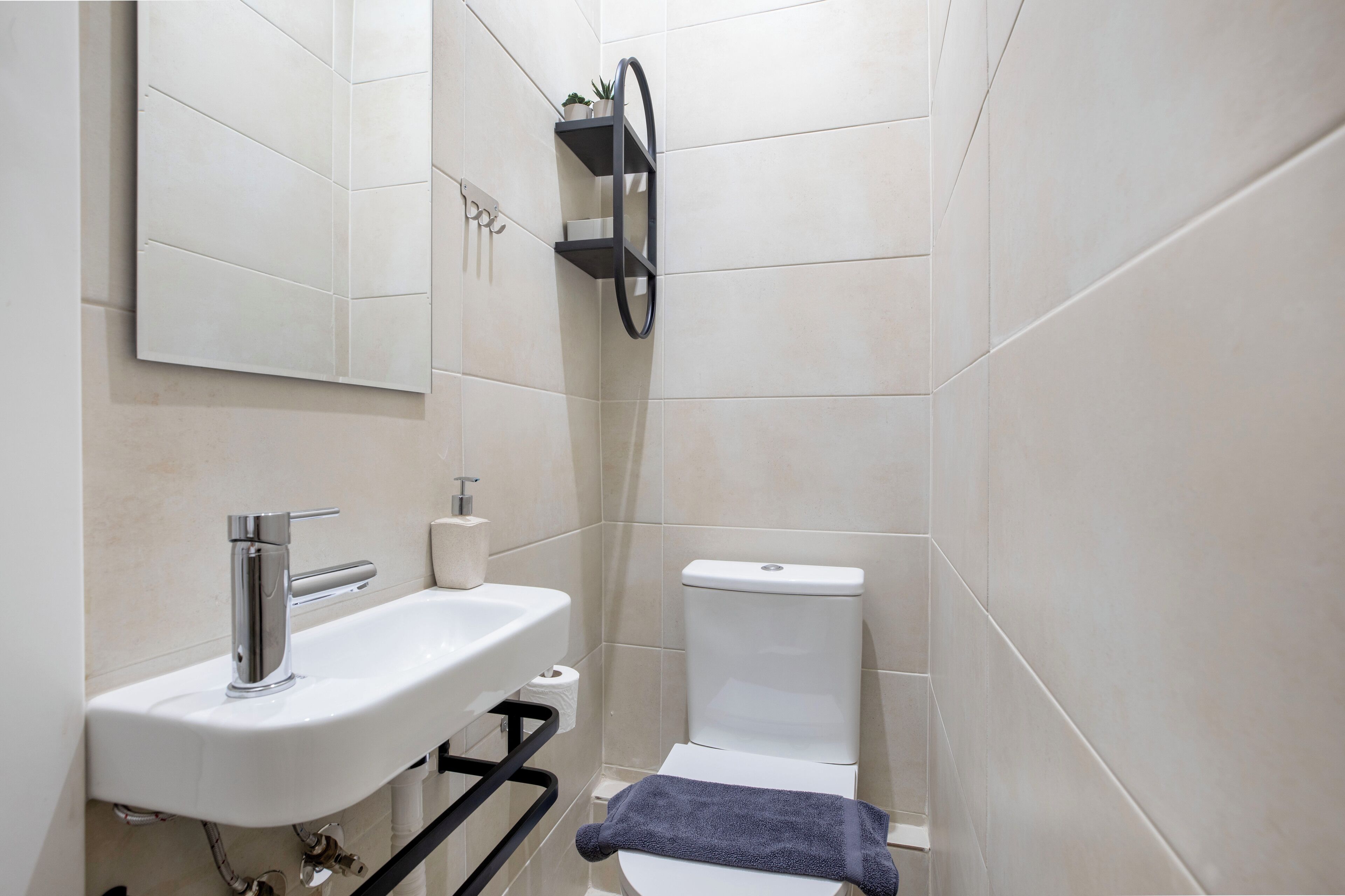 A bathroom with a white sink, toilet, and a towel rack.
