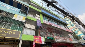 A multi-story building with various shops on the ground floor, including a corner shop and a refreshment store. - Hotel New Jatrabari (Dhaka)