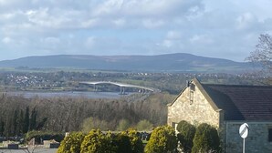 A stone building with a pointed roof, a no-entry sign, and a view of a bridge over a river with hills in the background. - Cosy Irish Cabin studio in fabulous Derry with WiFi & Private Bathroom (Derry)