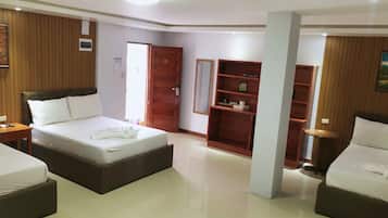 A hotel room with two beds, wooden paneling, a large mirror, and a wardrobe.
