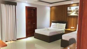 A hotel room with a bed, a bedside table, a nightstand, a mirror, a curtain, and a wooden panel wall with a painting.