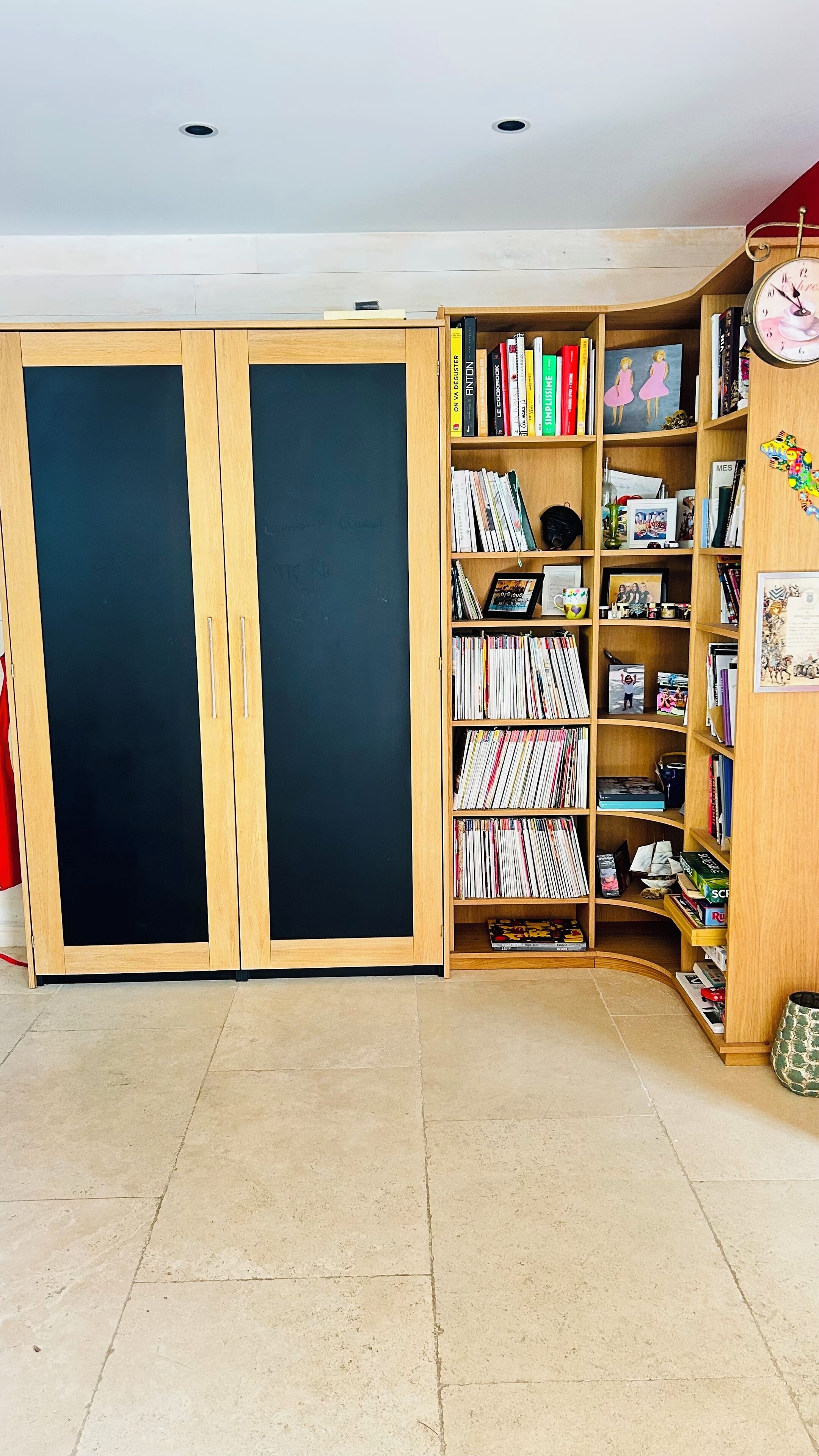 Una habitación con una estantería grande llena de libros y una pizarra.