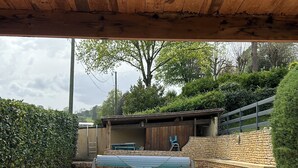A covered outdoor area with a swimming pool, brick flooring, and a lounge chair. - Comfortable air-conditioned villa - private heated swimming pool 3 kms from Sarlat center (PROISSANS)