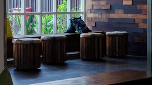 Een modern interieur met een groot raam, houten krukken en hangende lampen.