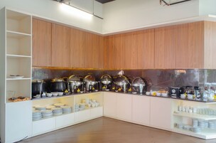 Una cocina con armarios de madera, encimera de acero inoxidable y varios electrodomésticos.
