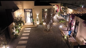 A courtyard with a central tree, a pool, and a seating area. - Voyage Itlalat Resort (Diryah)