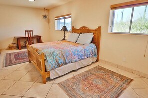 Une chambre avec un lit en bois, un bureau, une chaise, une table de chevet, une décoration en forme d’étoile, une fenêtre et un tapis.