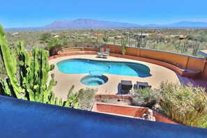 A pool with a view of mountains and desert landscape.