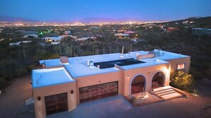 A modern house with a flat roof, a garage, and a driveway leading to the entrance.