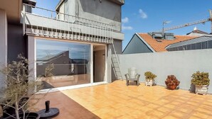A modern house with a balcony, a garage, and a tiled patio area with potted plants. - Hotiday Room Collection - Oporto (Porto)