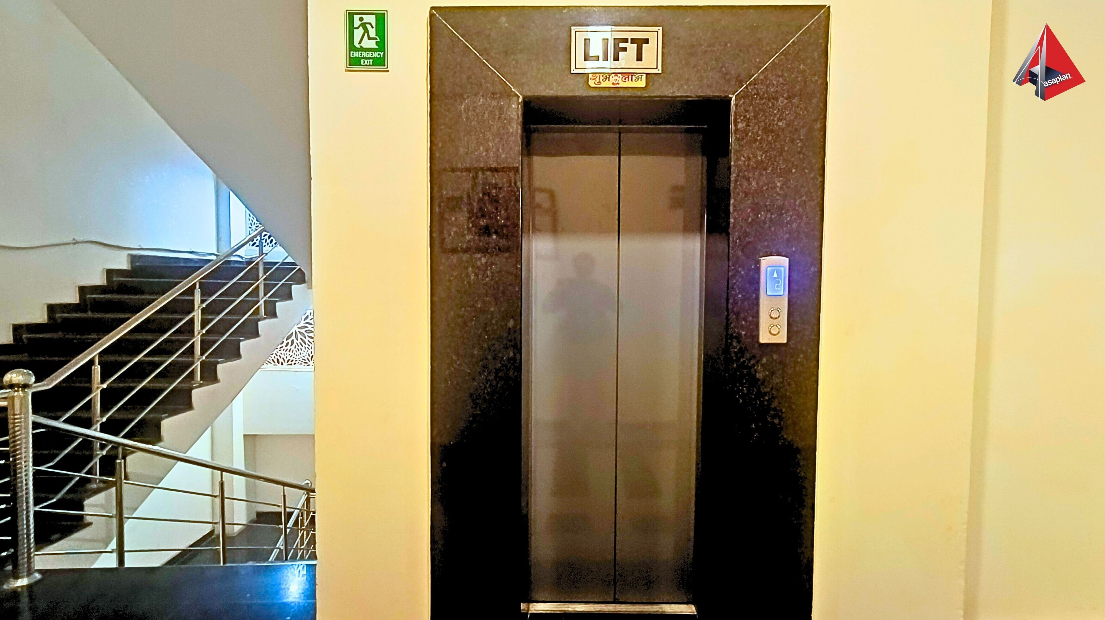 Ein Aufzug mit einem 'LIFT'-Schild und einem Notausgangsschild darüber.