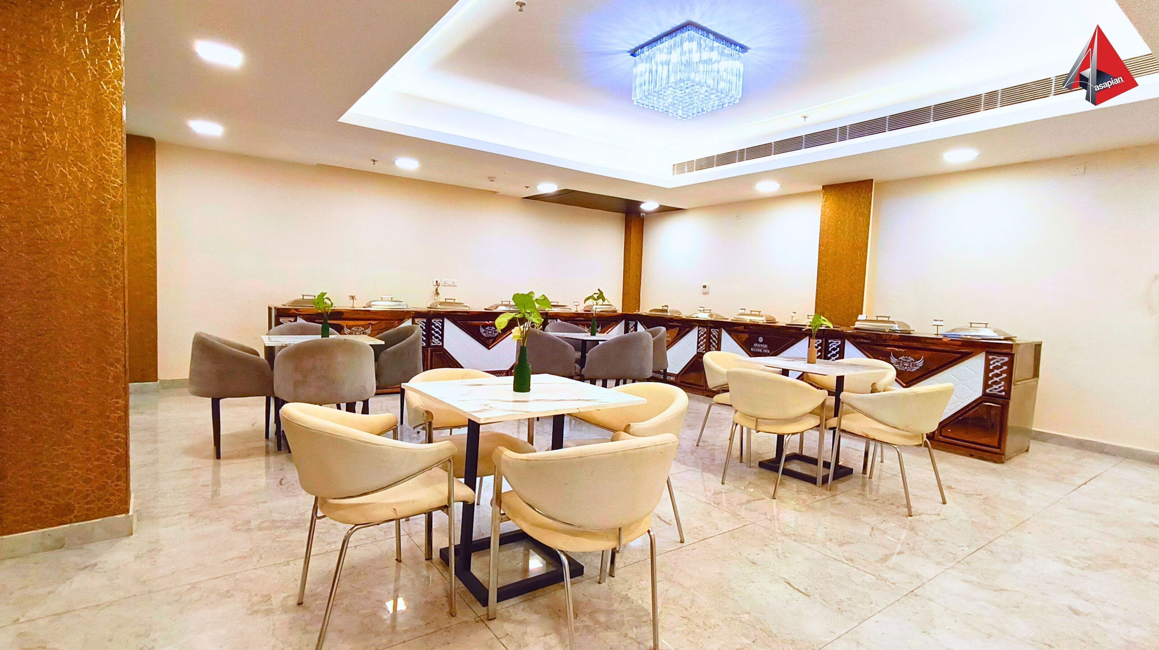 Un comedor de hotel con mesas y sillas, una araña y una recepción.