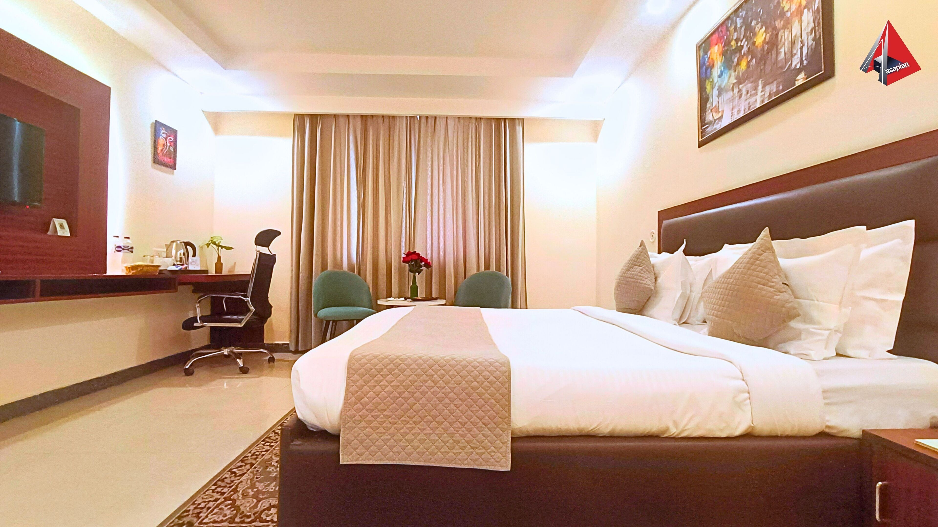 A hotel room with a large bed, a desk with a chair, a television, and a painting on the wall.