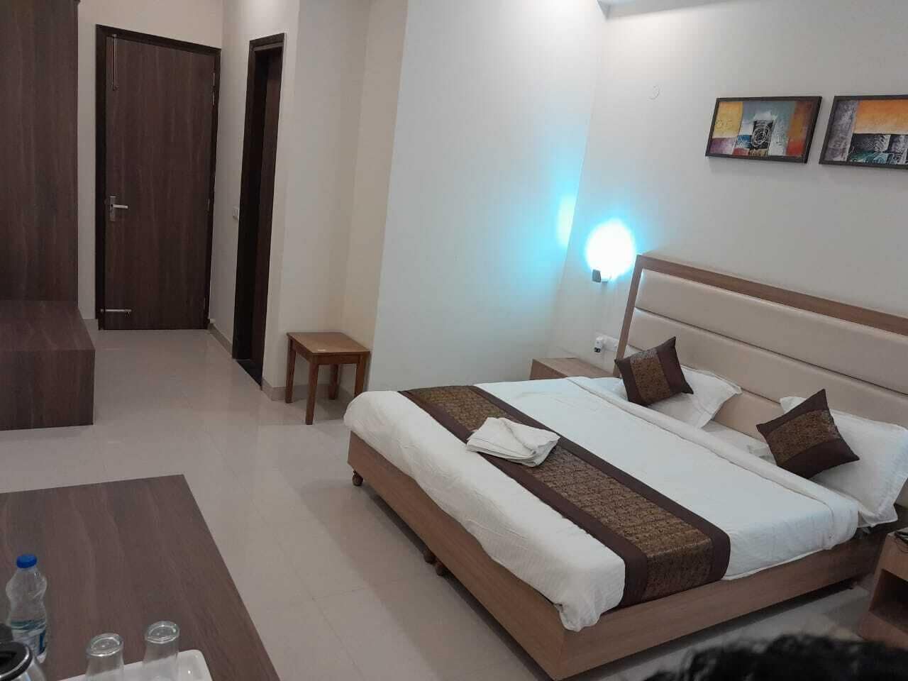 Una habitación de hotel con una cama grande, mesitas de noche, un escritorio y una silla.