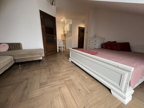 Un dormitorio con una cama, un sofá, un aparador y una silla.