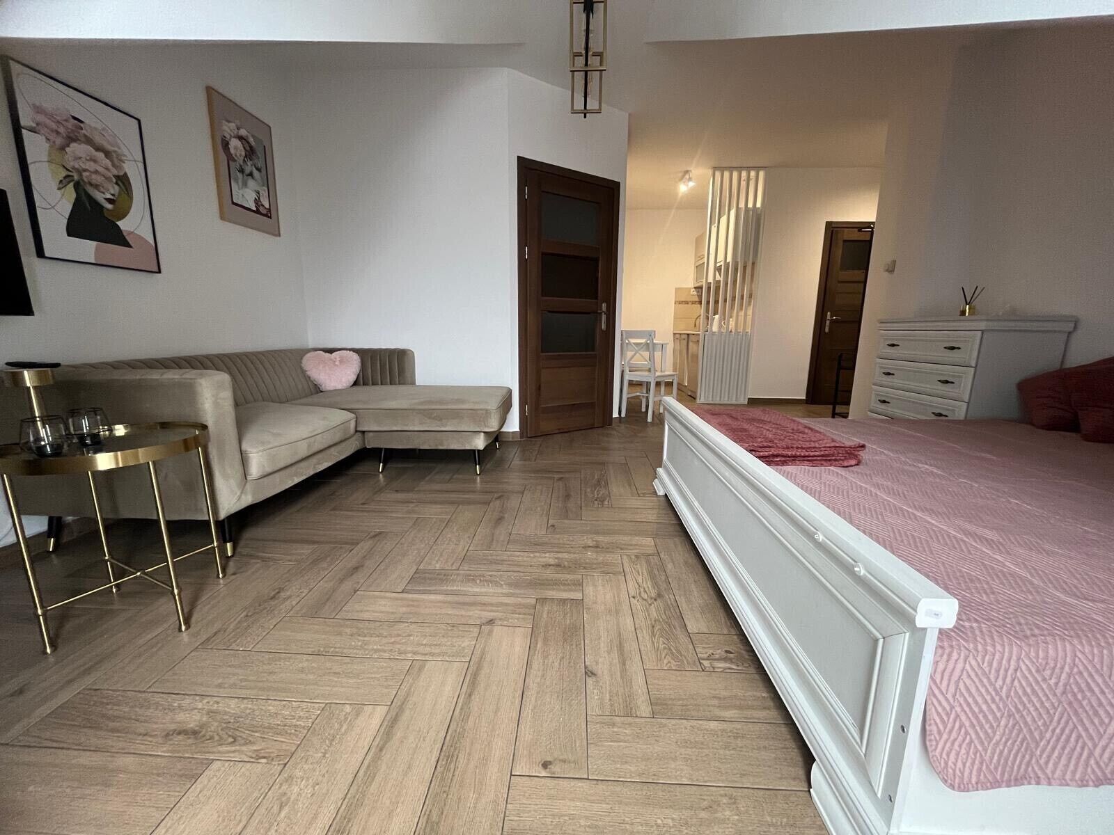 Une chambre à coucher avec un lit, un canapé, une petite table et une commode.