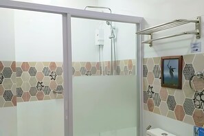 A bathroom with a shower, a toilet, and a sink. - Ferrymar Hotel Iloilo (Iloilo)