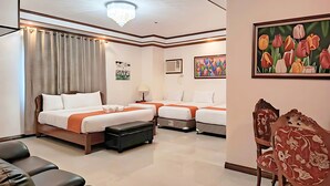 A hotel room with two beds, a desk, a chair, and a large window with curtains. - Ferrymar Hotel Iloilo (Iloilo)