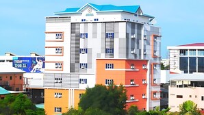 Un immeuble à plusieurs étages, doté d’un toit bleu, de plusieurs balcons et d’une antenne parabolique.