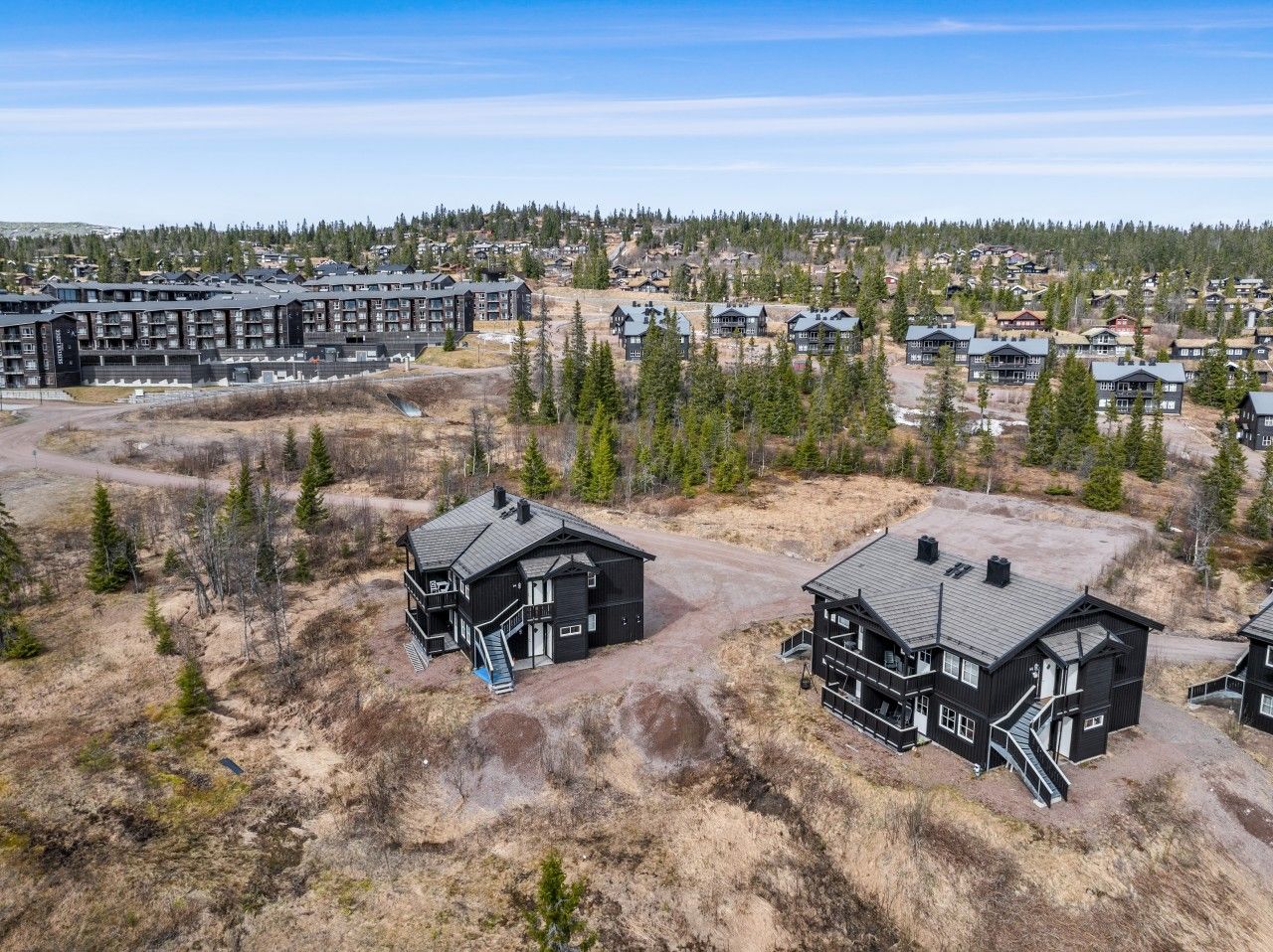 A residential area with multiple houses and a large building complex.