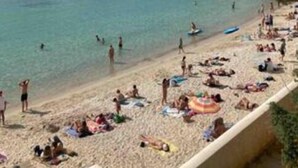 A beach with people sunbathing and swimming, a clear sky, and buildings in the background. - Studio 1 to 4 persons (Bandol)