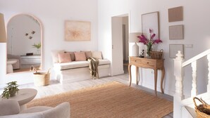 A spacious living room with a sofa, a coffee table, and a rug.