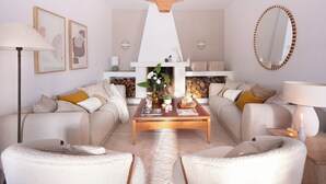 A living room with a fireplace, sofas, a coffee table, and a large mirror.