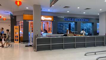 Spazio interno moderno con un negozio mobile, un negozio di parrucchiere e un'area dedicata al servizio clienti.