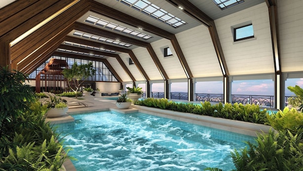 Una piscina interior moderna con vistas al horizonte de la ciudad, rodeada de exuberante vegetación y vigas de madera.